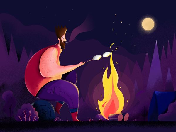 Man toasting marshmallows over campfire in the woods